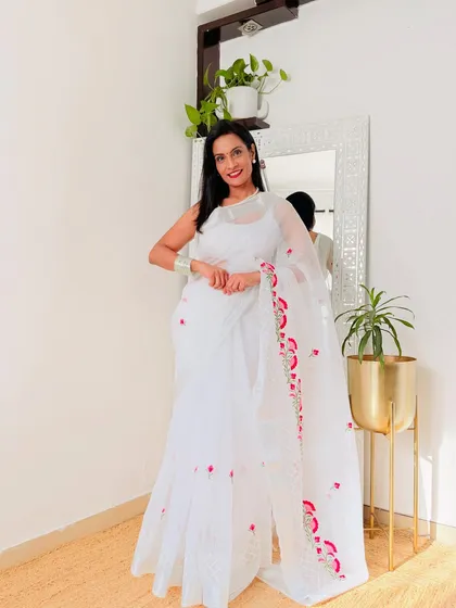 This white organza saree with pink floral embroidery is so ethereal and delicate. It's a perfect saree for a farewell party or a special daytime event.