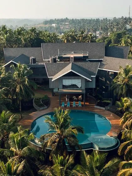 An aerial view of a contemporary residence in Mangalore, nestled within a lush grove of palm trees. This project highlights our approach to designing luxury homes that offer a private resort-like experience, blending indoor and outdoor living.