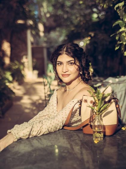 A vintage-themed outdoor shoot with Kat Diaries at a cafe in Colaba. The soft, dappled light creates a romantic and timeless feel.