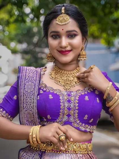 A model in a vibrant purple half saree, wearing our simple and elegant matt gold finish choker and jhumkas.