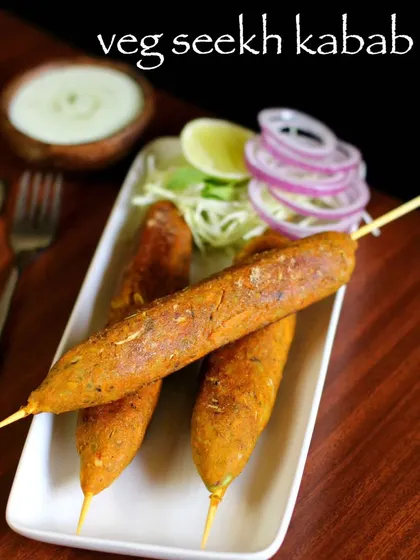 A simple, classic presentation of our Veg Seekh Kebabs, served with sliced onions and a side of creamy dip.