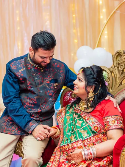 A sweet, intimate moment between the expecting couple, dressed in traditional Indian attire for their baby shower.