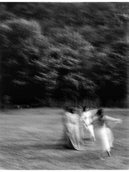 An artistic, motion-blur photo of dancers in a field. This experimental shot in black and white captures the feeling of freedom and movement.