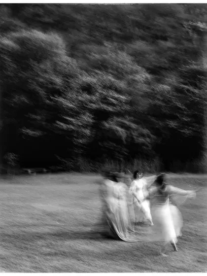 An artistic, motion-blur photo of dancers in a field. This experimental shot in black and white captures the feeling of freedom and movement.