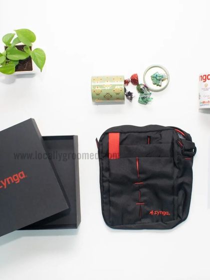 A welcome kit for Zynga featuring a custom sling bag, a mug, and a scented candle, all presented in a sleek black branded box. It's a great example of a simple yet thoughtful gift set.