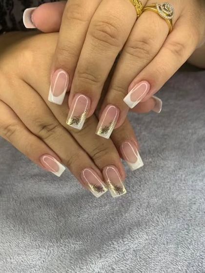 A classic square-tipped French manicure with two accent nails featuring a delicate gold leaf design.