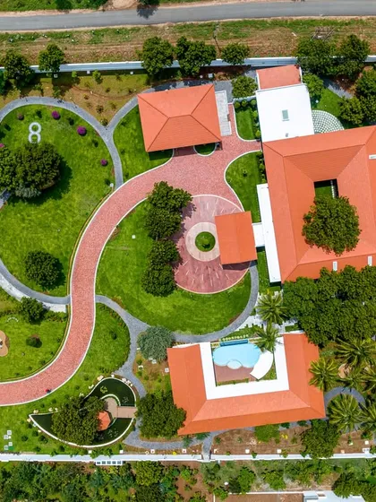 An aerial perspective of a sprawling farmhouse project showcasing our approach to integrated landscape and architectural design. We created a seamless flow between the built environment and curated green spaces, including distinct zones for living, leisure, and recreation.