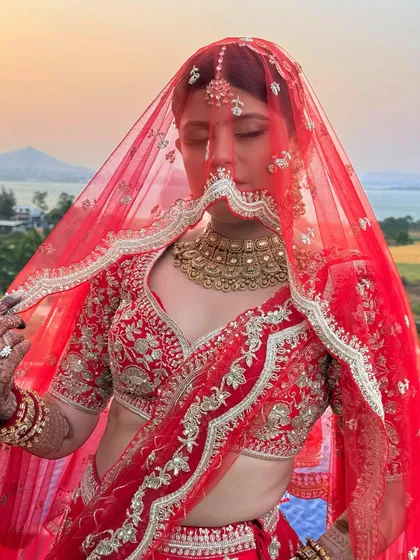 A beautiful shot of the bride under her red veil. The sheer fabric softens the look, creating an aura of mystery and romance, while her makeup glows through.