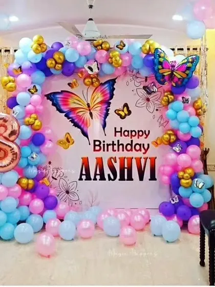 A vibrant butterfly-themed backdrop for a home birthday party. I use a mix of blue, pink, and purple balloons with gold accents and butterfly cutouts to create a beautiful photo corner.