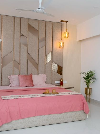 I was inspired to create a serene haven with this design, using gentle blush tones and metallic hints for a sense of calm luxury. The geometric, upholstered headboard acts as a stunning piece of art, making the space feel special.