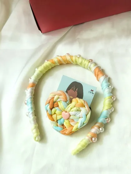 This is our 'Sweet Cinderella' Princess Braid headband and heart hair tie combo, featuring soft pastel colors and pearl accents.