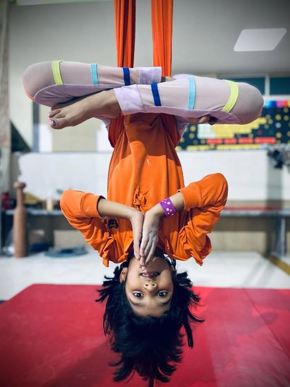 The world looks different upside down. This young yogi smiles while holding an inverted lotus pose, a fun and beneficial posture for all ages.