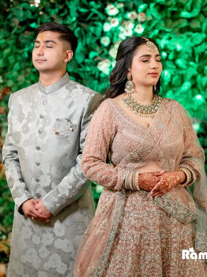 A serene portrait of the couple with their eyes closed, standing against a lush green backdrop. This image captures a moment of quiet connection and peace.