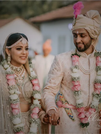 A beautiful shot of the couple right after their wedding ceremony. Their coordinated pastel outfits and the groom's loving gaze create a picture of pure romance.