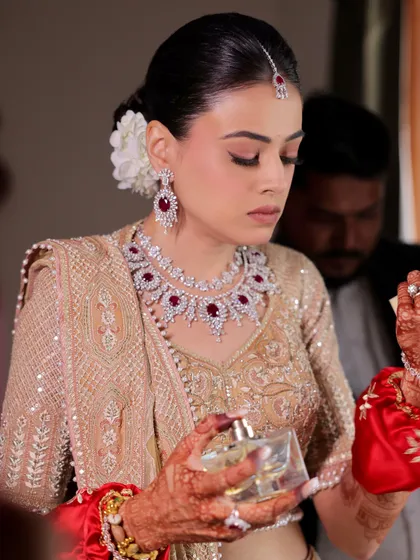 A beautiful, intimate moment before the ceremony begins. Every detail, from her makeup to her perfume, is part of her unique bridal story.