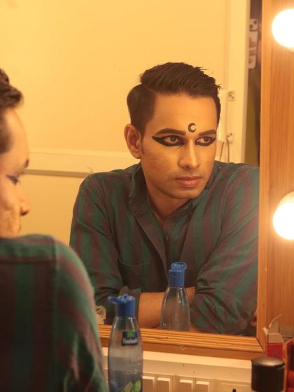 A candid moment in the green room, with the character's makeup on, but the performer's thoughts within.