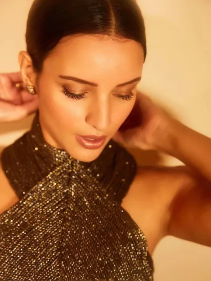 Here, I styled Tripti Dimri in a chic black dress by Nirmooha with a metallic halter neckline. It's a perfect example of a modern party dress that is both sophisticated and edgy.