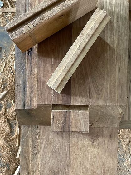 In our projects, wood is a unifying element that brings warmth. This image shows the meticulous joinery details we design, like half-lap and bridle joints, to ensure our custom furniture is strong, durable, and beautiful.