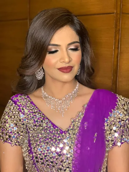 Bold lips, silk-like skin, and enchanting eyes. This was the perfect glamorous look for Yesha's sangeet, complementing her purple mirror-work outfit.