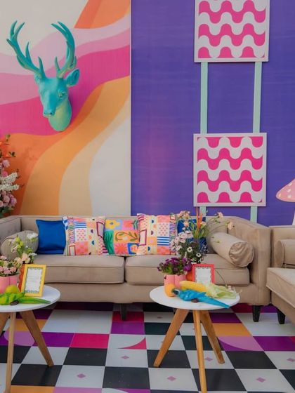 I created vibrant and comfortable lounge areas that combined eclectic patterns, bold colors, and whimsical props. This space shows a mix of checkerboard floors, patterned cushions, and quirky animal sculptures, ensuring every corner was visually stimulating.