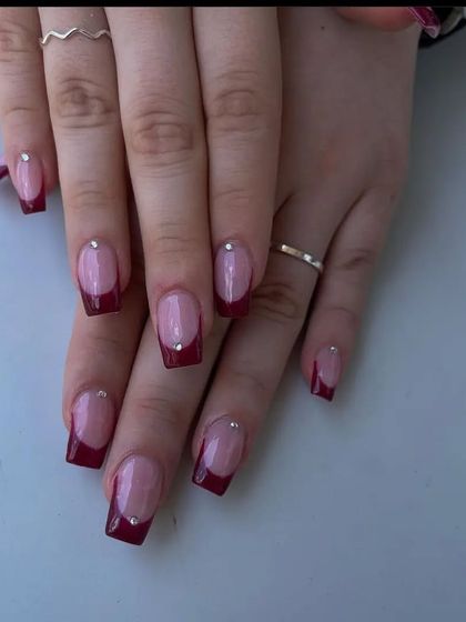 A sophisticated French manicure with a deep maroon tip on square-shaped nails, each accented with a single tiny rhinestone.