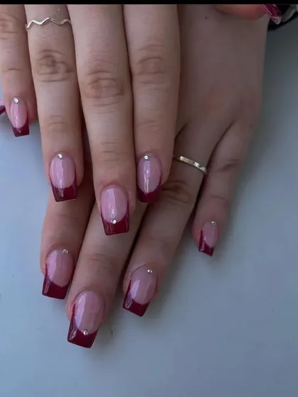 A sophisticated French manicure with a deep maroon tip on square-shaped nails, each accented with a single tiny rhinestone.