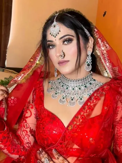 A bride in a red sequin lehenga wearing an American Diamond and emerald necklace set. This piece adds a touch of color and a lot of sparkle.