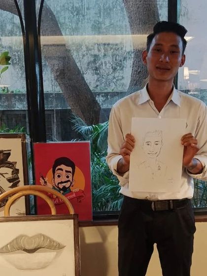 A staff member at Cafe Noir with his caricature. I love sketching the hardworking staff at the venues I visit.