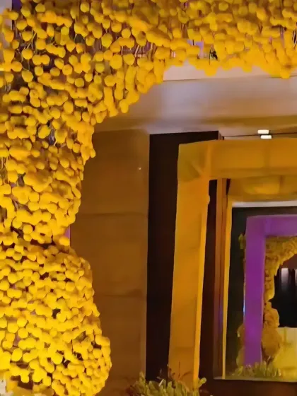 A dense archway made entirely of yellow marigolds, creating a powerful and traditional statement piece for a Haldi ceremony entrance.