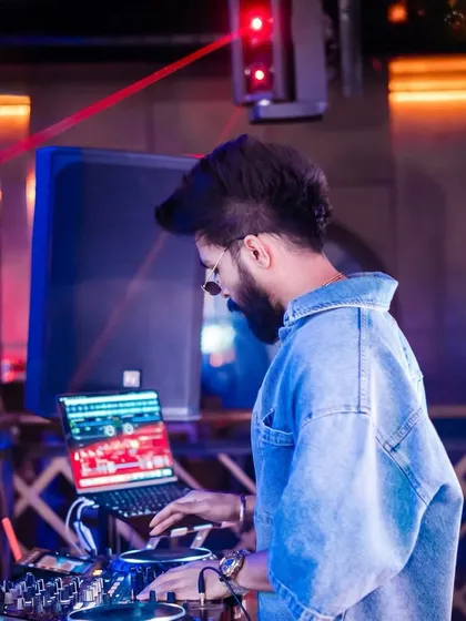 A side profile shot of me focused on my laptop and mixer. This is where I line up the next banger to keep the party going.