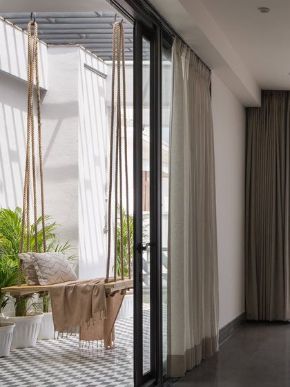 The verandah at Hikari House is designed as a flexible breakout space. A simple wooden swing and potted plants turn this small balcony into an expansive, light-filled retreat.