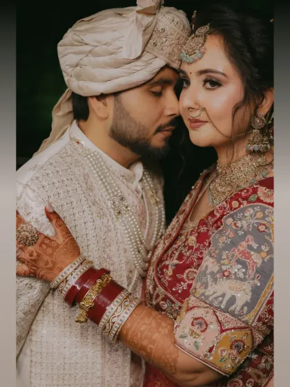 An intimate close up of the bride and groom. Her intricate henna, the rich red of her bangles, and their gentle embrace tell a story of love and tradition.