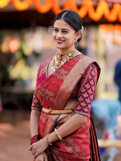 A candid shot of a client in her red Banarasi saree and custom brocade blouse. The outfit is perfect for weddings and festive occasions.
