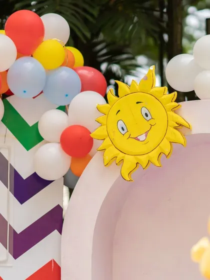 A smiling sun prop, part of the Cocomelon decor, adding a touch of brightness and joy to the celebration.