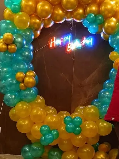 A vibrant balloon ring in chrome gold and green. The "Happy Birthday" neon sign in the center makes it a great focal point for party pictures.