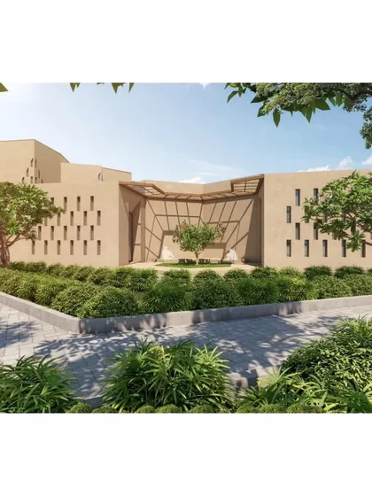 The entrance to one of the buildings at Qism Al Tahfeez, framed by trees and landscaping to create a gentle transition from the outdoors.