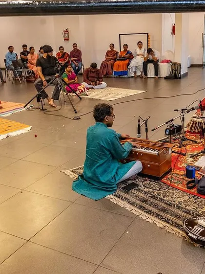 The same musical event, seen from a different angle, showing the setup of microphones and instruments that help carry the sacred sounds to everyone in the space.