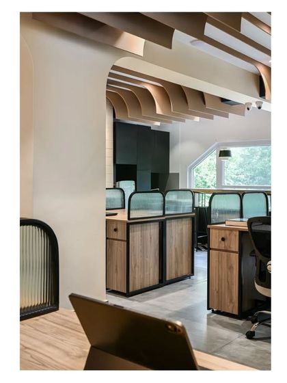 A perspective from one of the workstations, looking out into the main office area. The arched fins create beautiful frames, wrapping the entire space in a cohesive design language.