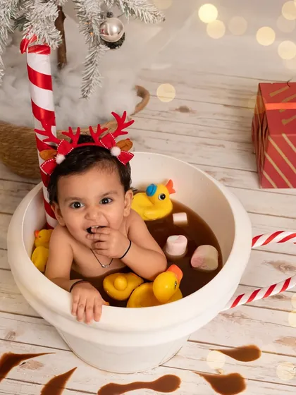 Getting a little taste of the 'hot chocolate' and marshmallows. These playful, interactive sessions are designed to be fun for the baby, resulting in genuine smiles and adorable messes.