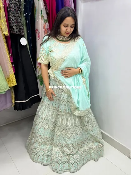 Another shot of the client admiring the fit and design of the light blue lehenga. The color is fresh and the design is modern yet traditional.