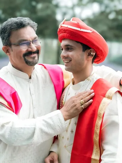A proud father shares a happy moment with his son, the groom, just before the wedding ceremony.
