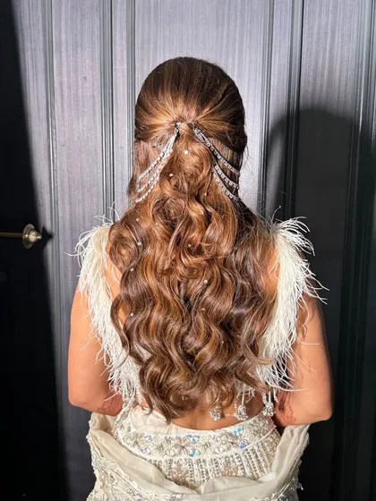 A glamorous hairstyle for the sister of the bride. This look features voluminous waves and sparkling, cascading hair accessories for a show-stopping effect.