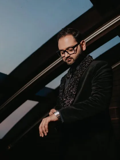 A classic portrait of the groom, looking thoughtful and stylish before his Sangeet performance.