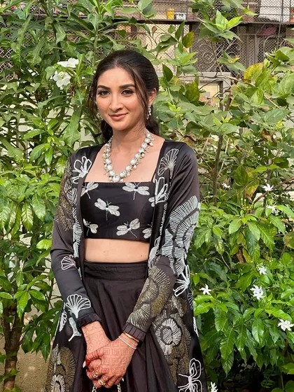 A full view of this modern, nature-inspired look. The makeup is minimal and elegant, letting the unique outfit be the star.