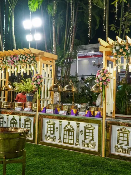 Another angle of the outdoor buffet station, showing the arrangement of the chafing dishes under a decorated wooden pergola. It's a complete setup that looks great day or night.