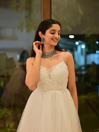 A soft, ethereal look for a fashion event. The makeup is minimal and glowy, paired with loose waves to complement the delicate white gown.