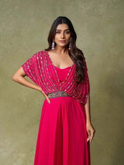 A simple and elegant three-quarter portrait for a lookbook. The focus is on the draped silhouette of this pink gown, clearly presenting the garment to potential buyers.