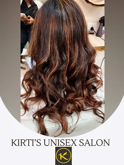 A close-up of hair with rich copper and brown highlights, styled in beautiful curls. This shows how color can enhance texture and movement.