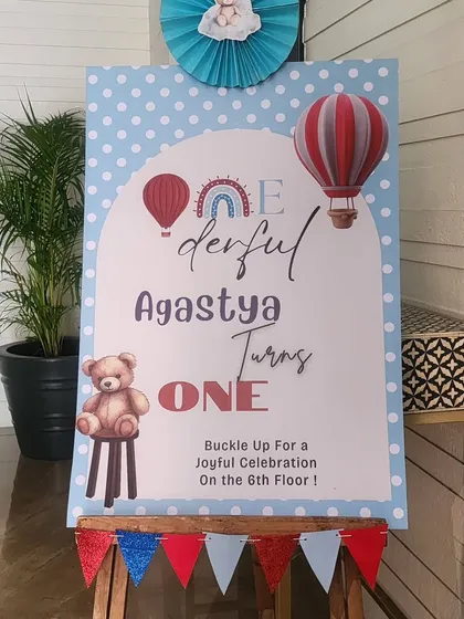 The main welcome sign for Agastya's "one-derful" first birthday. The sign uses playful fonts and graphics, and cleverly directs guests to the 6th floor celebration.