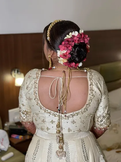For this bride's wedding, I created a beautiful floral bun using a mix of pink and white flowers. It's a classic and romantic choice that never goes out of style.